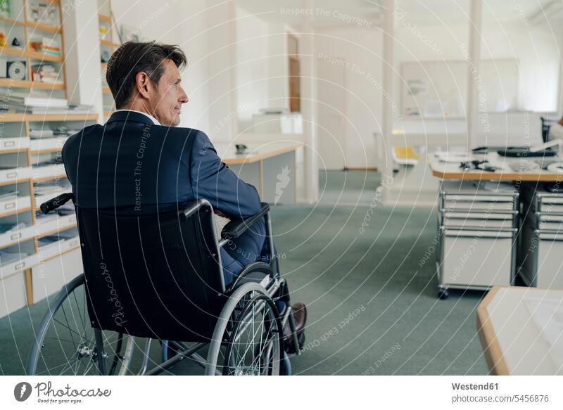 Behinderter Geschäftsmann sitzt im Rollstuhl Erfolg Erfolge erfolgreich nachdenken überlegen Businessmann Businessmänner Geschäftsmänner Büro Office Büros