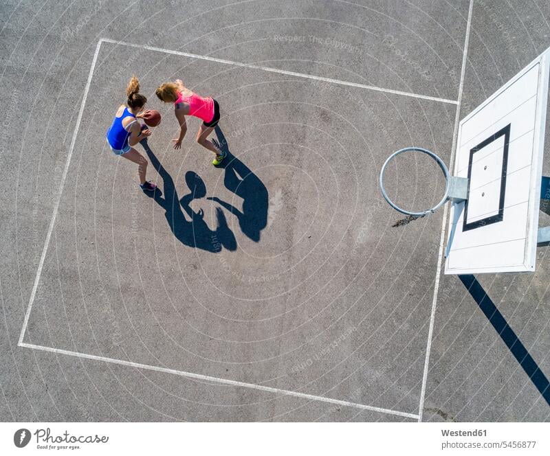 Junge Frauen beim Basketball spielen, Luftaufnahme Basketballkorb Basketballkoerbe Basketballkörbe Sport Sportplatz Sportplaetze Sportplätze Freizeit Muße Hobby