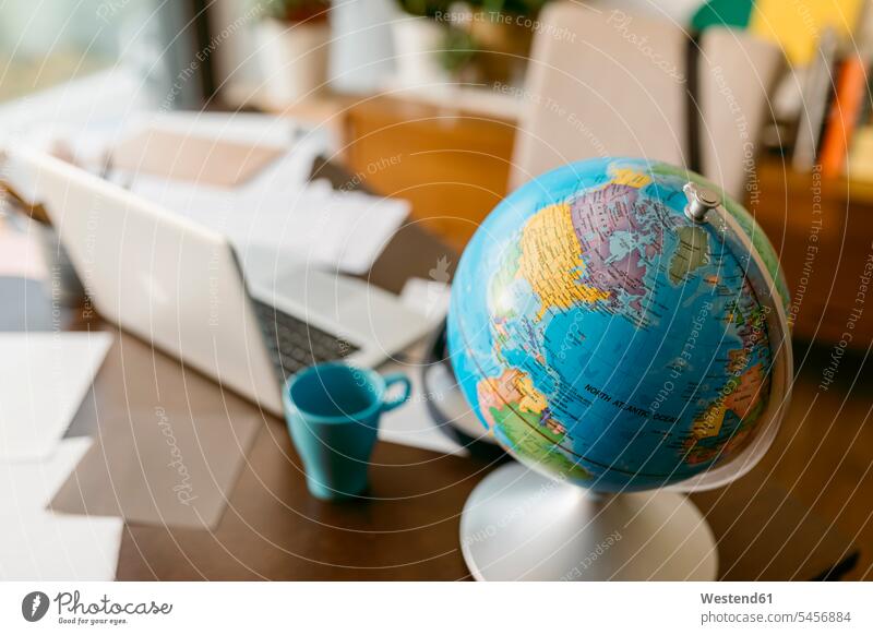 Globus mit Laptop und Tasse auf dem Tisch Farbaufnahme Farbe Farbfoto Farbphoto Innenaufnahme Innenaufnahmen innen drinnen Spanien Zimmer Raum Räume