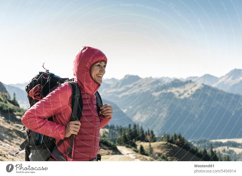Österreich, Tirol, lächelnde Frau auf einer Wanderung in den Bergen, die die Aussicht genießt weiblich Frauen Gebirge Berglandschaft Gebirgslandschaft