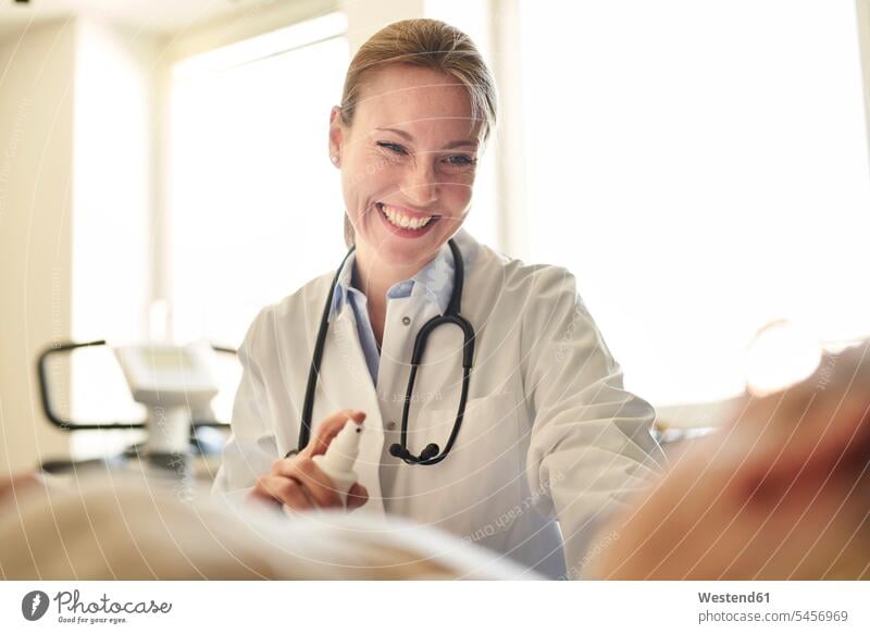 Lächelnde Ärztin bei der Vorbereitung einer Blutentnahme bei einem Patienten in einer Arztpraxis vorbereiten Doktoren Ärzte Untersuchung mustern Untersuchungen