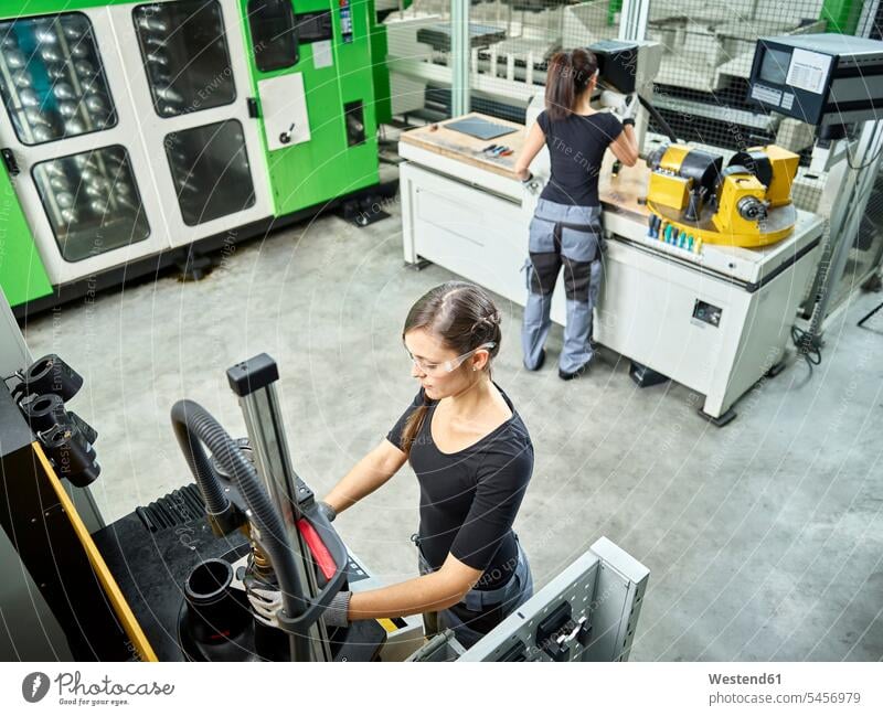 Junge Frau arbeitet an einer Maschine Österreich Männerberuf Arbeiterin Arbeiterinnen Metallverarbeitung Standbohrmaschine Bohrmaschine Standbohrmaschinen
