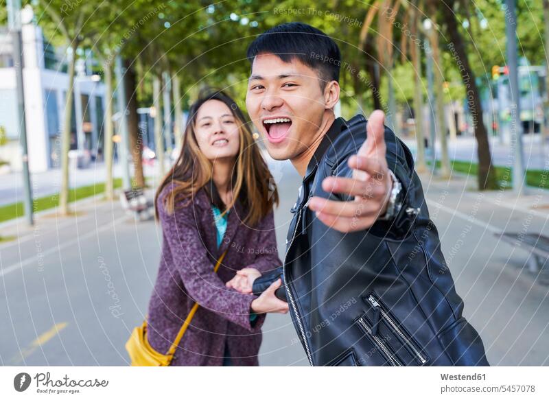 Glückliches Paar, das jemanden zu einem Spaziergang einlädt, Barcelona, Spanien Leute Menschen People Person Personen Asiaten Asiatisch asiatische
