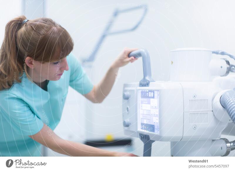 Radiologin beim Einstellen eines Röntgengeräts Leute Menschen People Person Personen Europäisch Kaukasier kaukasisch 1 ein Mensch nur eine Person single