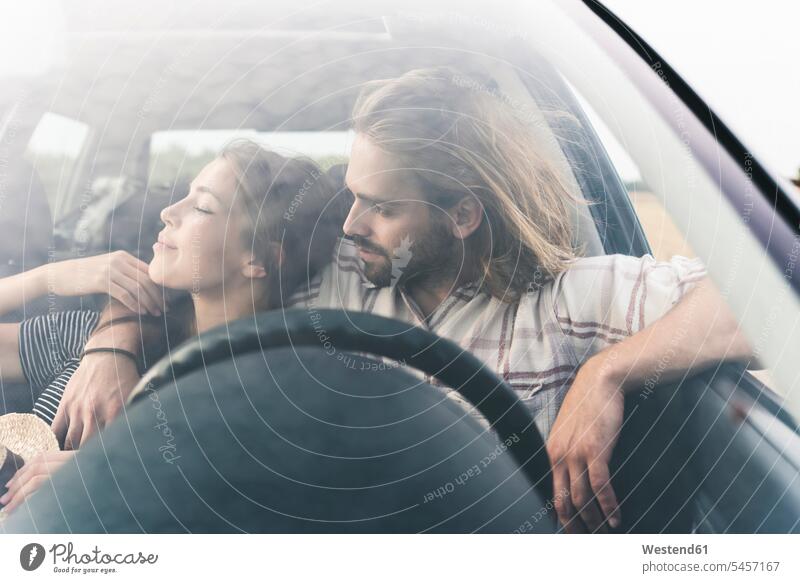 Zärtliches junges Paar in einem Auto Wagen PKWs Automobil Autos Pärchen Paare Partnerschaft Zuneigung Kraftfahrzeug Verkehrsmittel KFZ Mensch Menschen Leute