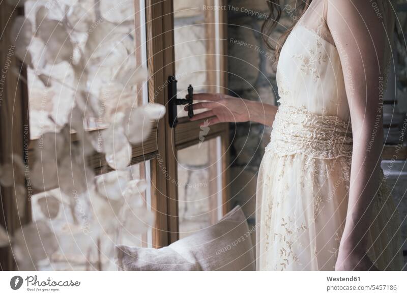 Junge Frau in elegantem Brautkleid öffnet Fenster Innenaufnahme Innenaufnahmen innen indoor Contemporary Freisteller freigestellt Serie Serien Studioaufnahme