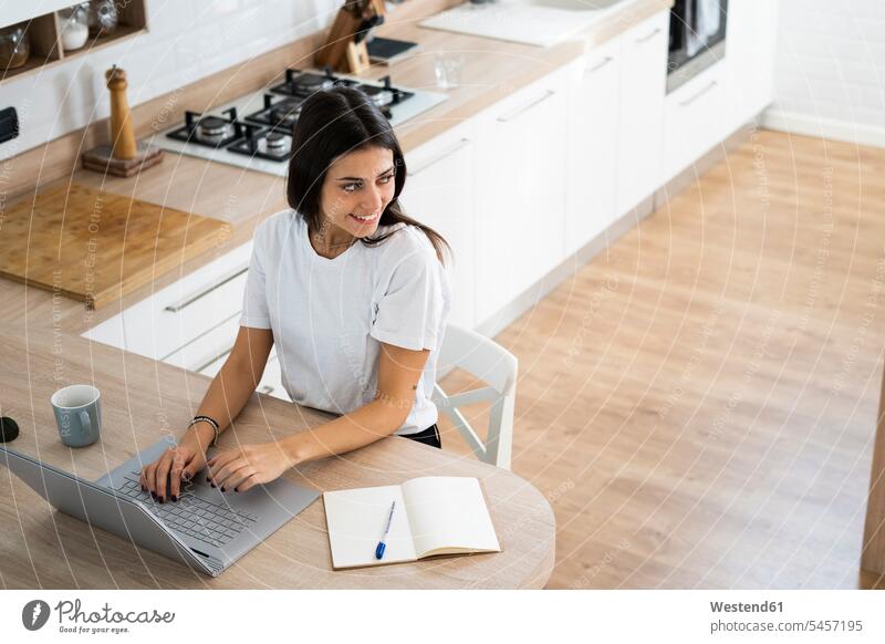 Lächelnde junge Frau mit Laptop zu Hause Leute Menschen People Person Personen Alleinstehende Alleinstehender Singles Unverheiratete Unverheirateter Job Berufe