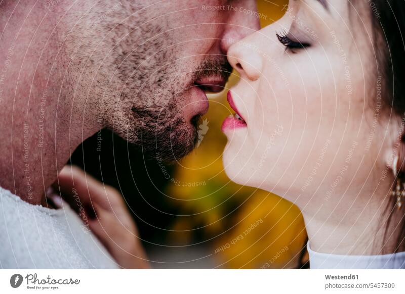 Schöne Frau küsst männlichen Partner, während sie im Freien steht Farbaufnahme Farbe Farbfoto Farbphoto Außenaufnahme außen draußen Tag Tageslichtaufnahme
