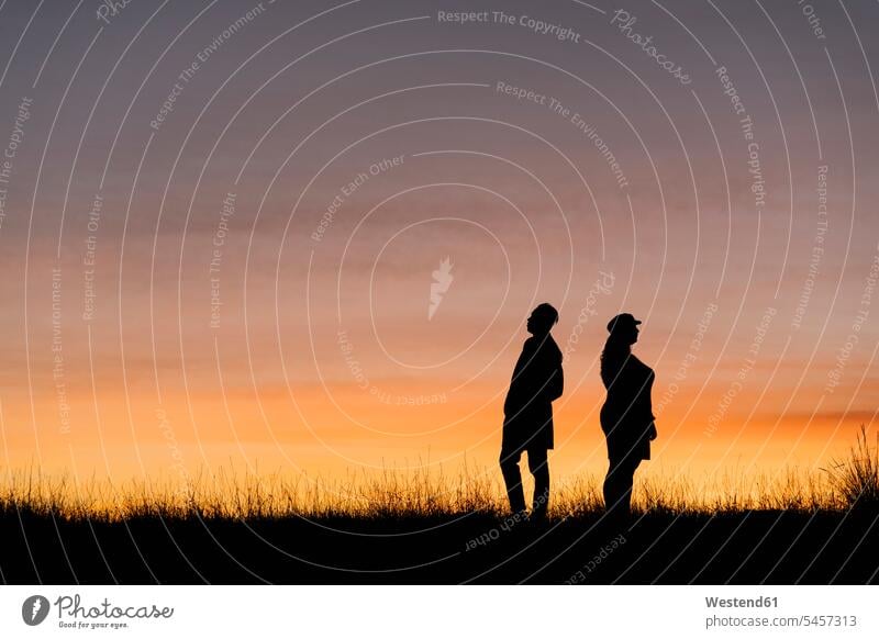 In Silhouette von Mann und Frau stehen gegen den Himmel Farbaufnahme Farbe Farbfoto Farbphoto Außenaufnahme außen draußen im Freien Sonnenuntergang