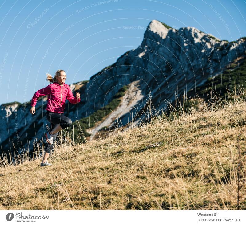 Österreich, Tirol, Frau beim Laufen in den Bergen Gebirge Berglandschaft Gebirgslandschaft Gebirgskette Gebirgszug weiblich Frauen laufen rennen Landschaft