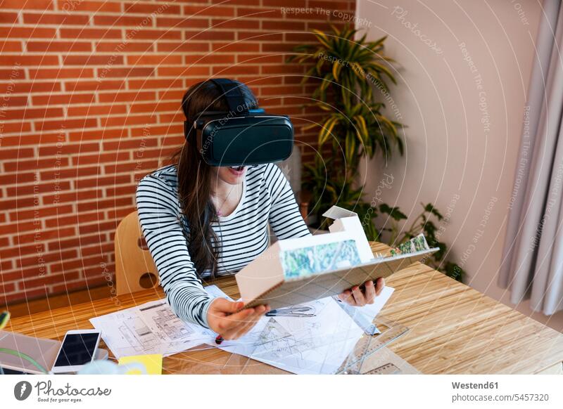 Junge Frau, die im Architekturbüro arbeitet, betrachtet Modell mit VR-Brille entwerfen Entwurf Architektin Architektinnen Virtual Reality Brille