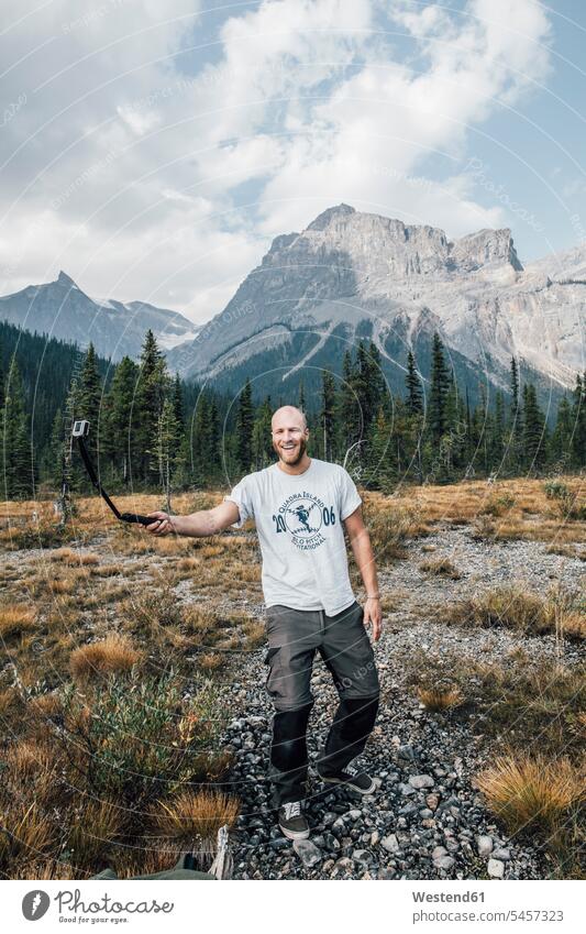 Kanada, British Columbia, Yoho National Park, glücklicher Mann mit Selfie-Stick Portrait Porträts Portraits Männer männlich Erwachsener erwachsen Mensch