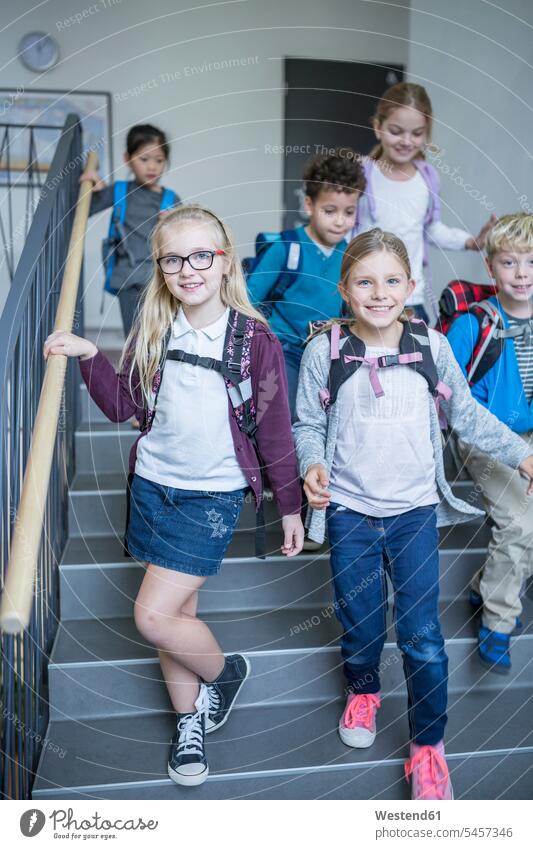 Glückliche Schüler auf der Treppe beim Verlassen der Schule Schulen verlassen Treppenhaus Treppenhäuser Treppenhaeuser glücklich glücklich sein glücklichsein