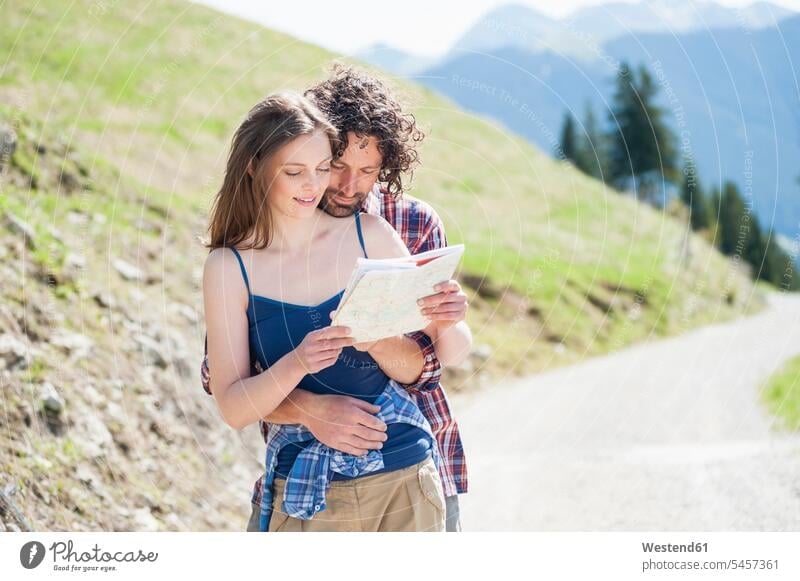 Wanderndes Wanderpaar schaut auf Karte, Wallberg, Bayern, Deutschland knuddeln schmusen Arm umlegen Umarmung Umarmungen sommerlich Sommerzeit gefühlvoll