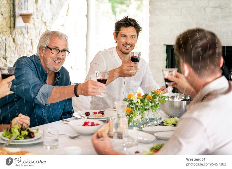 Glückliche Familie mit Mahlzeit zusammen klirren Weingläser Mahlzeiten Essen Speise Speisen glücklich glücklich sein glücklichsein Weinglas anstoßen zuprosten