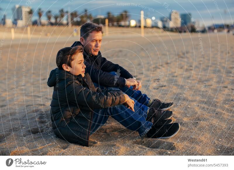 Vater und Sohn sitzen am Strand Beach Straende Strände Beaches sitzend sitzt Söhne Papas Väter Vati Vatis Papis Kind Kinder Familie Familien Mensch Menschen