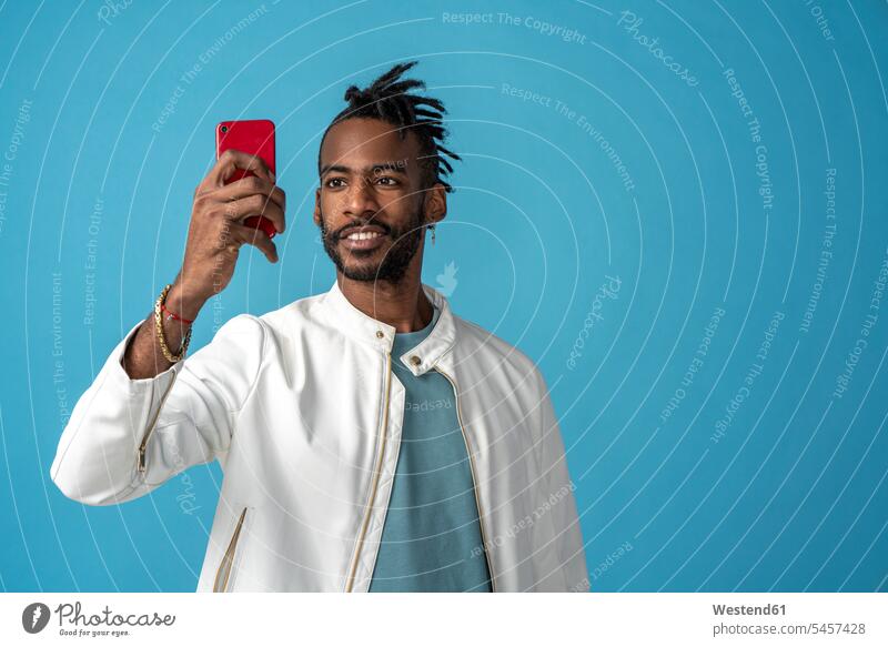Porträt eines stilvollen jungen Mannes, der ein Selfie macht Jacken Telekommunikation telefonieren Handies Handys Mobiltelefon Mobiltelefone zufrieden Farben