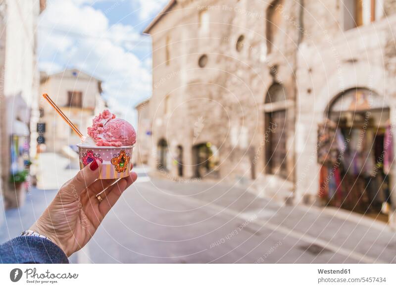 Italien, Umbrien, Assisi, Frauenhand hält ein traditionelles italienisches Gelato im Stadtzentrum Eisbecher Becher Fokus Auf Den Vordergrund