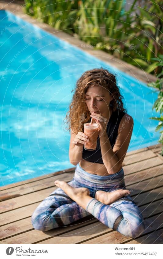 Frau übt Yoga am Pool, trinkt Saft, Costa Rica frontal Frontalansicht Frontalaufnahme Frontalaufnahmen von vorne Gläser Trinkglas Trinkgläser Leute Menschen
