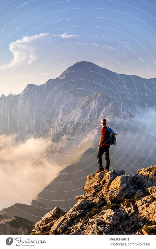 Wanderer steht und bewundert die Aussicht auf den Berg der Bergamasker Alpen, Italien Farbaufnahme Farbe Farbfoto Farbphoto Außenaufnahme außen draußen