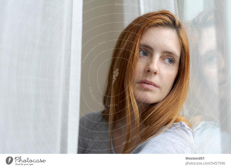 Porträt einer seriösen jungen Frau, die aus dem Fenster schaut Leute Menschen People Person Personen Europäisch Kaukasier kaukasisch 1 Ein ein Mensch