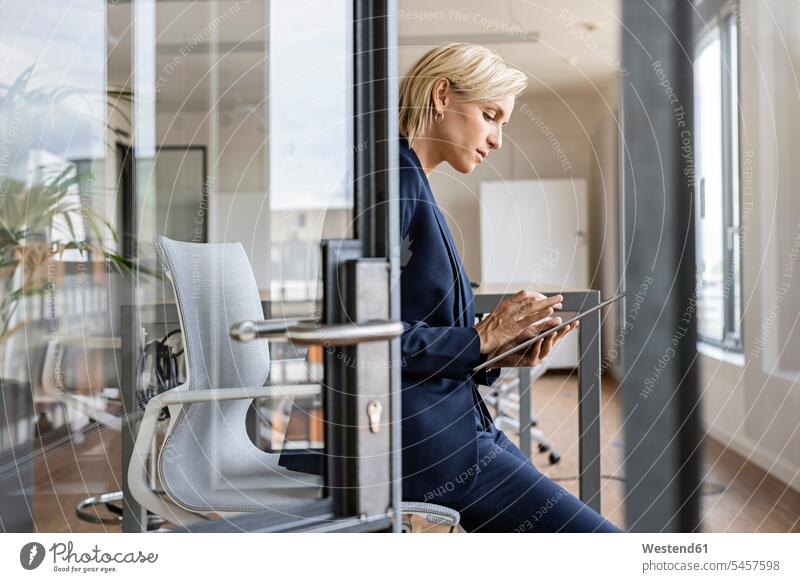 Blonde Geschäftsfrau benutzt Tablet im Konferenzraum Job Berufe Berufstätigkeit Beschäftigung Jobs geschäftlich Geschäftsleben Geschäftswelt Geschäftsperson