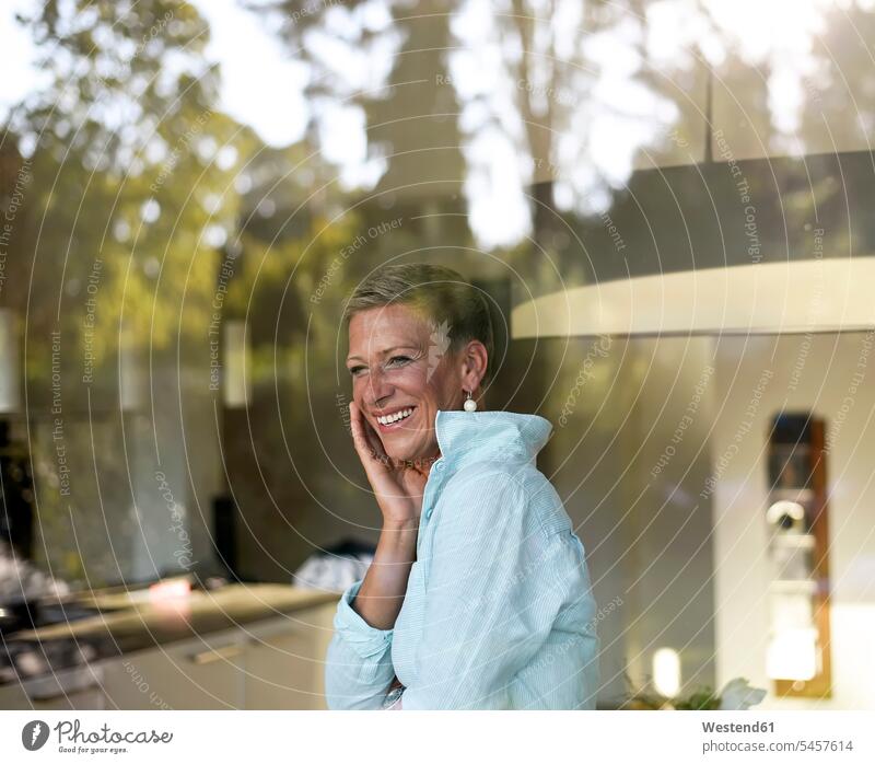 Porträt einer lachenden Frau, die aus dem Fenster schaut Portrait Porträts Portraits weiblich Frauen schauen sehend Erwachsener erwachsen Mensch Menschen Leute