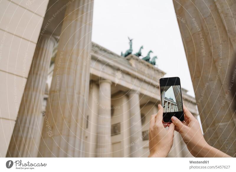 Schnittansicht der Hände, die das Branderburger Tor mit einem Smartphone fotografieren, Berlin, Deutschland Handies Handys Mobiltelefon Mobiltelefone Displays