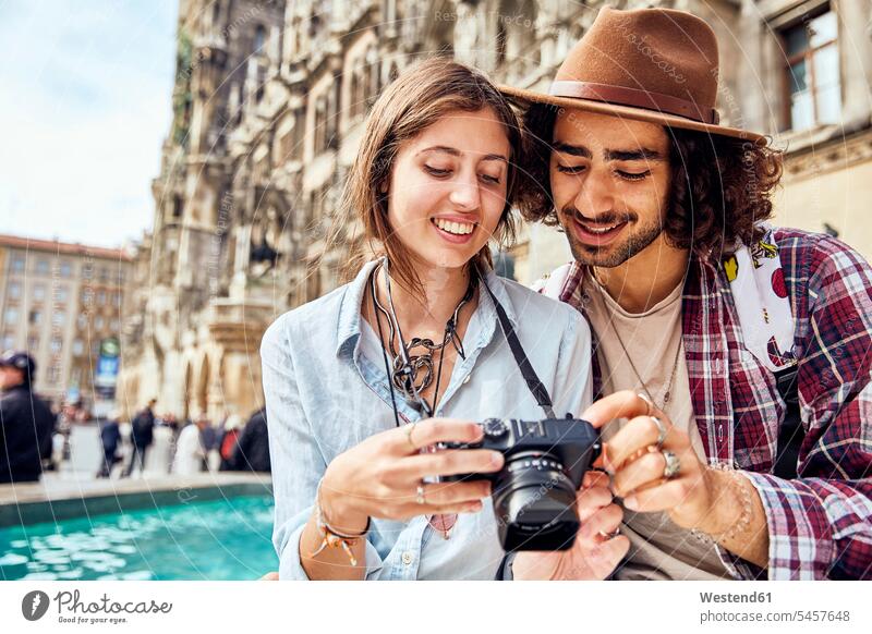Junges Paar beim Fotografieren Freunde Kameradschaft Bilder Bildnis Fotos Hüte Fotokamera Kameras freuen Glück glücklich sein glücklichsein zufrieden Muße