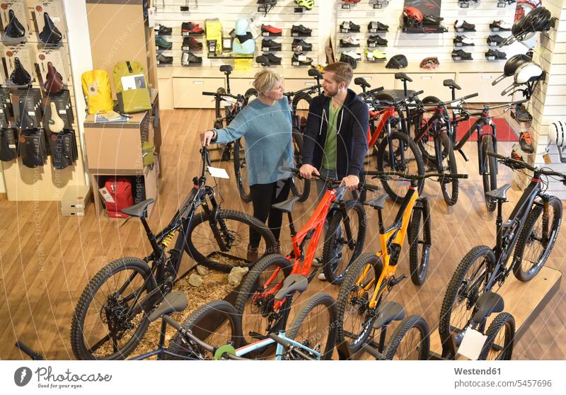 Verkäufer hilft Kunde im Fahrradgeschäft Kundin verkaufen Bikes Fahrräder Räder Rad Fachverkäufer Fahrradmechaniker Geschäft Shop Laden Läden Geschäfte Shops