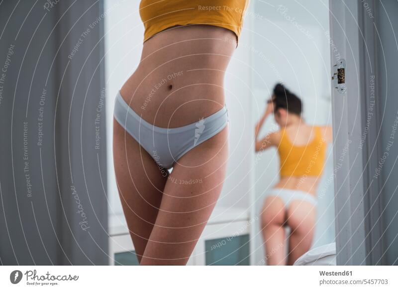 Junge Frau in Unterwäsche zu Hause im Spiegel reflektiert Spiegelung Spiegelungen schön Zuhause daheim weiblich Frauen Reflexion Reflexionen