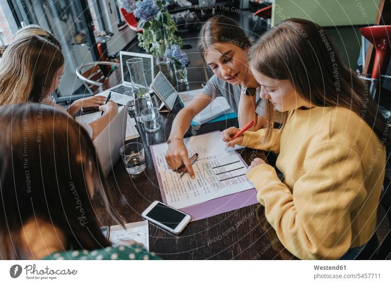 Mädchen im Teenageralter, die von zu Hause aus studieren und lernen und sich gegenseitig unterstützen gemischtrassige Person Europäer fünf Personen Teenagerin