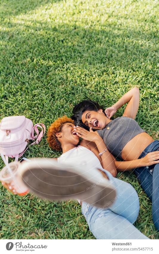 Zwei sorglose Freundinnen entspannen sich in einem Park entspannt entspanntheit relaxt glücklich Glück glücklich sein glücklichsein Unbeschwert Sorglos