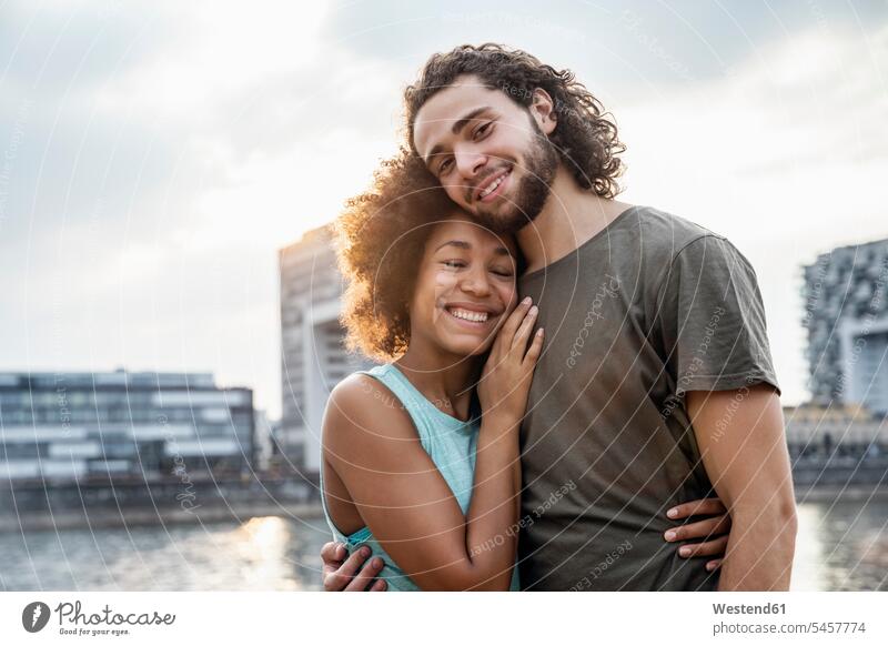 Deutschland, Köln, Porträt eines glücklichen Paares am Flussufer Glück glücklich sein glücklichsein Portrait Porträts Portraits entspannt entspanntheit relaxt