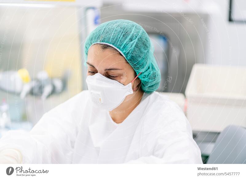 Nahaufnahme einer Apothekerin mit chirurgischer Maske und Kappe bei der Arbeit im Labor Farbaufnahme Farbe Farbfoto Farbphoto Spanien Innenaufnahme