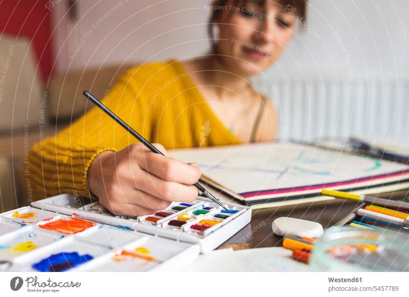 Hand einer Frau, die mit Aquarellfarben malt Job Berufe Berufstätigkeit Beschäftigung Jobs Tische Arbeit daheim zu Hause Muße Kreativ drinnen Innenaufnahmen