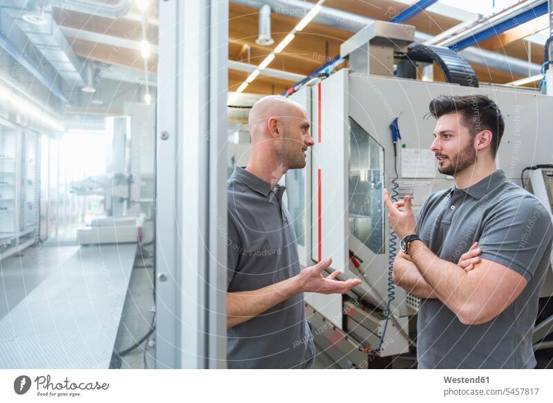 Zwei Männer diskutieren an einer Maschine in einer modernen Fabrik besprechen Besprechung Mann männlich Maschinen Fabriken Erwachsener erwachsen Mensch Menschen