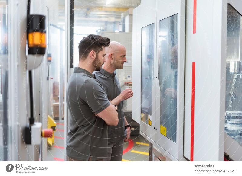 Zwei Männer untersuchen Maschine in moderner Fabrik prüfen Mann männlich Fabriken Maschinen Untersuchung mustern Untersuchungen beutachten Erwachsener erwachsen