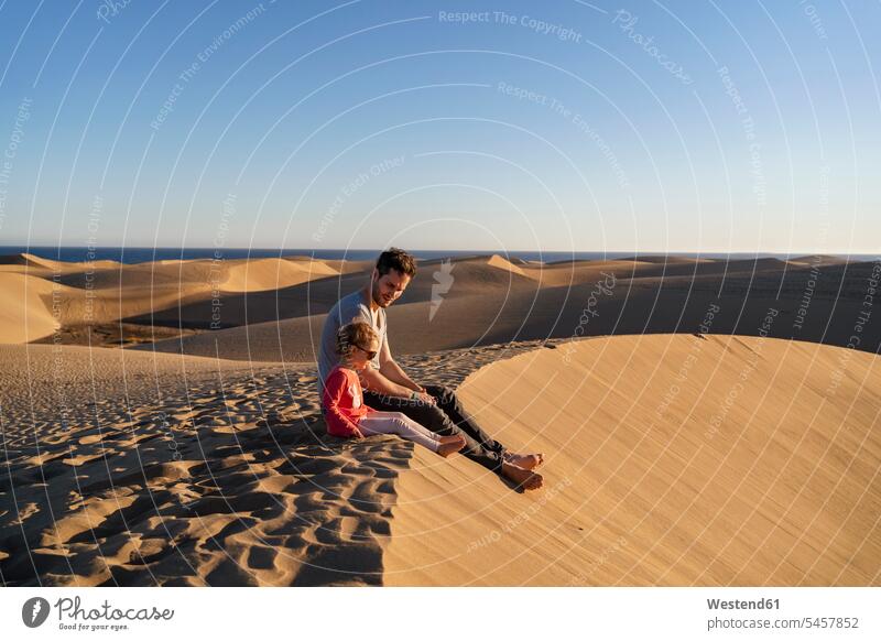 Vater und Tochter sitzen auf einer Sanddüne, Gran Canaria, Spanien Touristen Brillen Sonnenbrillen entspannen relaxen sitzend sitzt entspanntheit relaxt frei