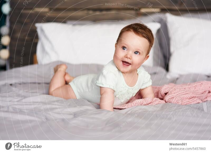 Glückliches Baby liegt zu Hause im Bett Betten Zuhause daheim glücklich glücklich sein glücklichsein Babies Babys Säuglinge Kind Kinder liegen liegend Mensch