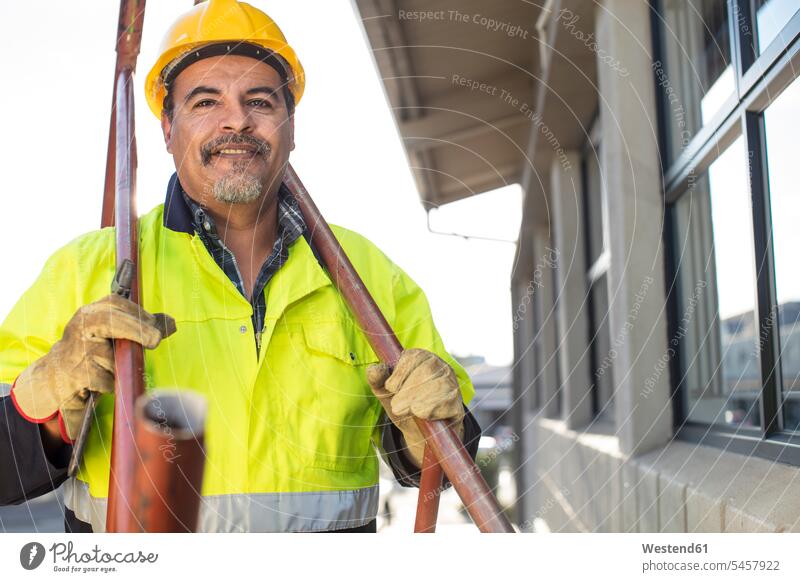 Südafrika, Kapstadt, Builder hält Rohre Sicherheitsweste Weste Arbeiter Beruf Berufstätigkeit Berufe Beschäftigung Jobs lächeln Bauarbeiter Leuchtweste