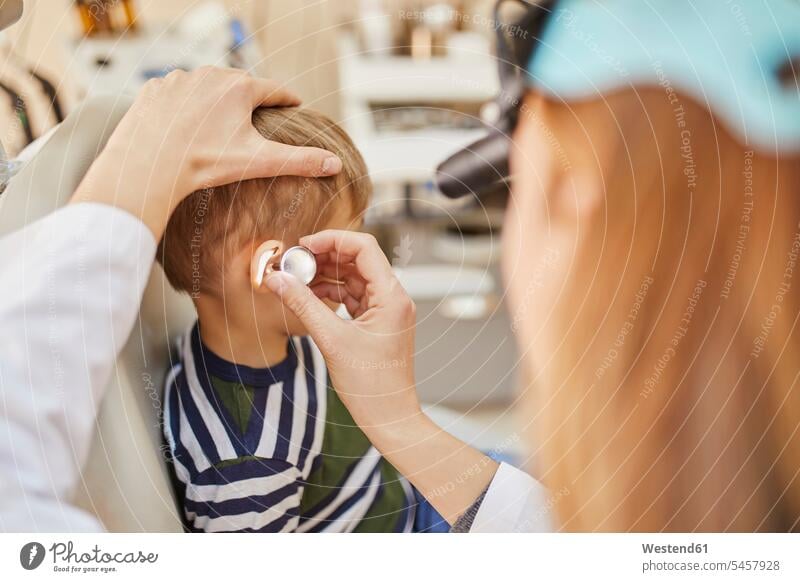 HNO-Arzt untersucht Ohr eines Jungen Ohren Ärztin Aerztin Ärztinnen Doktorinnen Aerztinnen Buben Knabe Knaben männlich untersuchen prüfen Mensch Menschen Leute