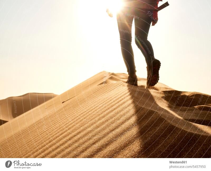 Niedriger Abschnitt einer Frau, die auf dem Kamm einer Düne in der Wüste erwacht, Walvis Bay, Namibia (value=0) gehend geht Erlebnisse erforschen Erforschung