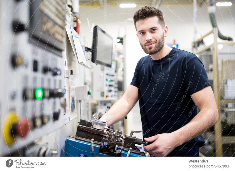 Porträt eines selbstbewussten Mannes, der in einer modernen Fabrik an einer Maschine arbeitet Job Berufe Berufstätigkeit Beschäftigung Jobs Arbeiter T-Shirts