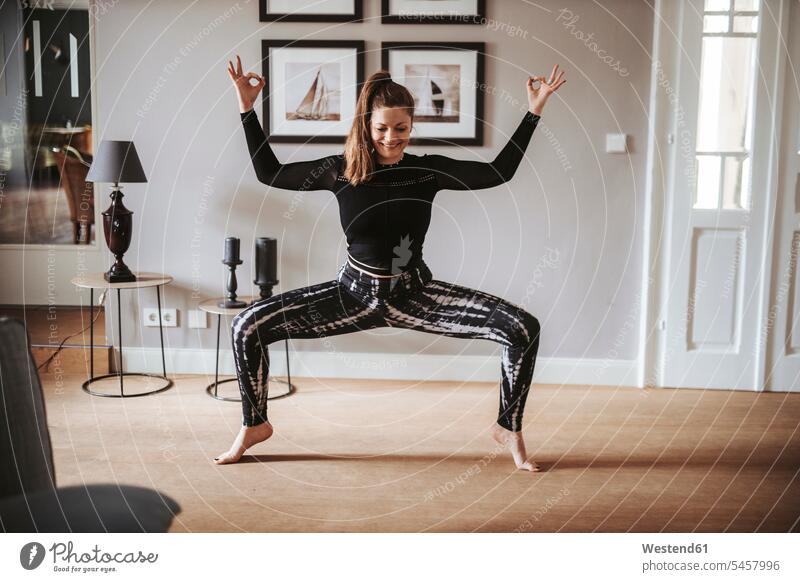 Frau praktiziert Yoga zu Hause freuen Glück glücklich sein glücklichsein zufrieden daheim Muße ausgeglichen Ausgeglichenheit Gleichgewicht trainieren Grund Land