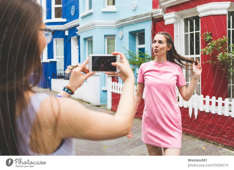 Teenager-Mädchen macht Handyfoto von junger Frau in der Stadt Mobiltelefon Handies Handys Mobiltelefone Teenagerin junges Mädchen Teenagerinnen weiblich