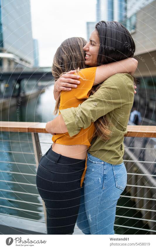 Glückliches lesbisches Paar umarmt sich in der Stadt, London, UK Arm umlegen Umarmung Umarmungen freuen glücklich sein glücklichsein gefühlvoll Emotionen