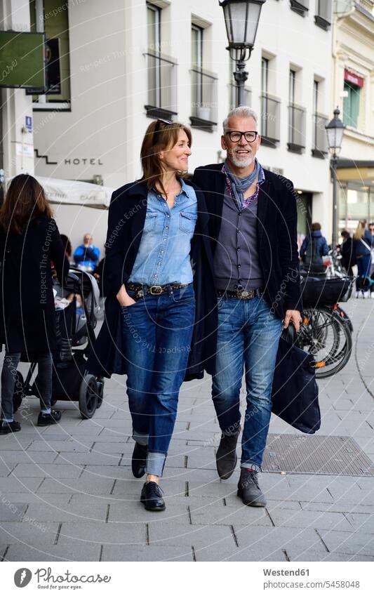 Reifes Paar, das in der Stadt spazieren geht, mit Armen um Taschen gehend Kauf Einkauf Einkaufen shoppen shopping freuen Frohsinn Fröhlichkeit Heiterkeit