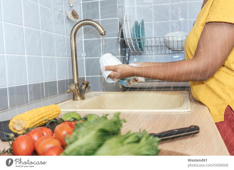 Nahaufnahme einer Frau, die in der Küche eine Tasse wäscht Leute Menschen People Person Personen Afrikanisch Afrikanische Abstammung dunkelhäutig Farbige
