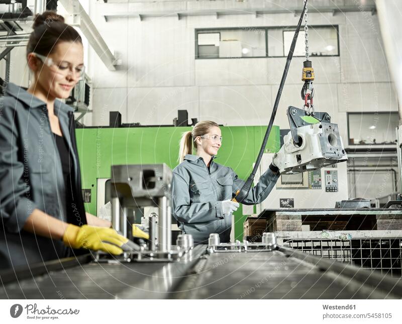Zwei Frauen arbeiten an einer Maschine Arbeitskleidung Arbeitsbekleidung Männerberuf Zusammenarbeit Kooperation zusammenarbeiten zusammen arbeiten Teamwork
